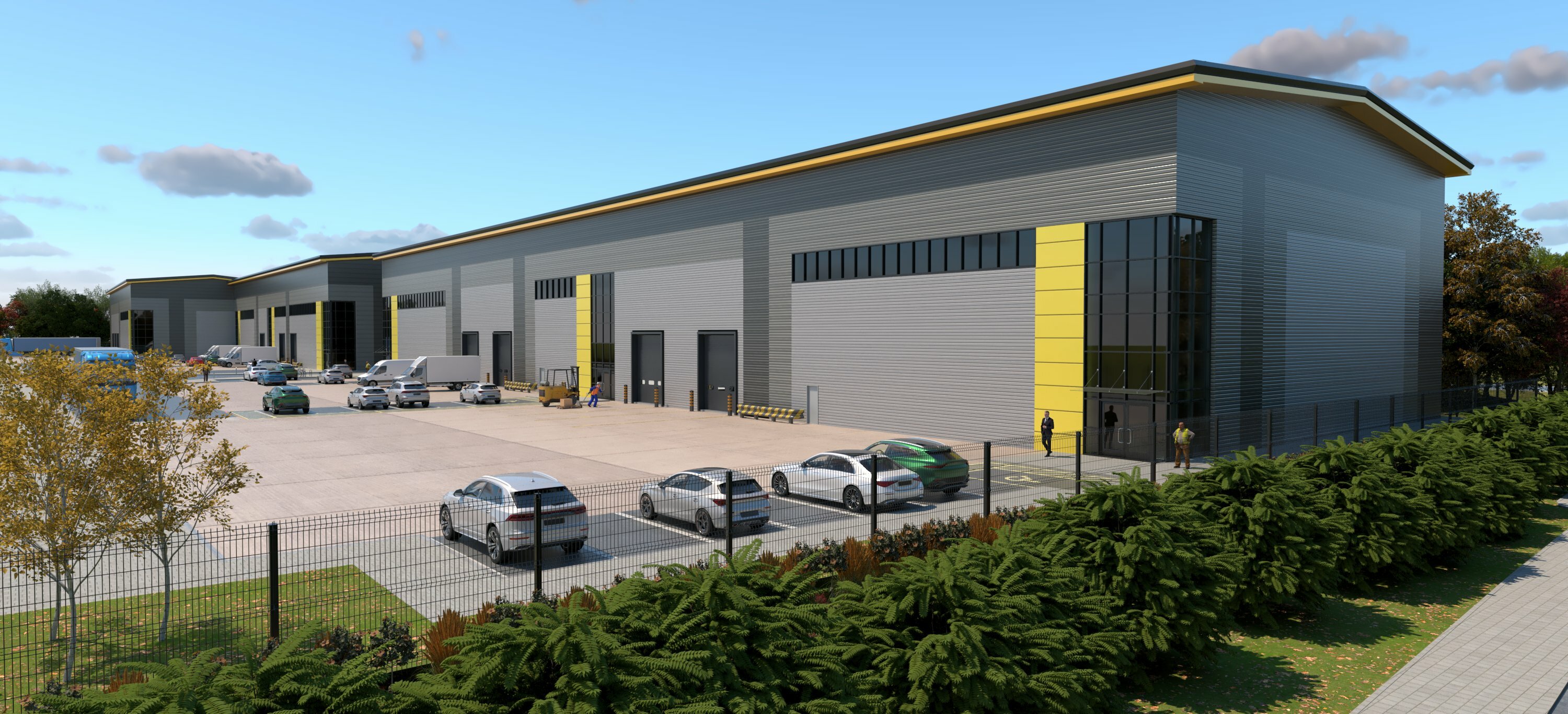 Modern grey industrial warehouse with yellow accent trim, large roller doors, car park with white and dark vehicles, blue sky.