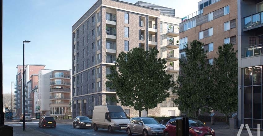 Street view of a modern multi-story residential building with balconies, located in an urban area with cars and trees in the foreground.