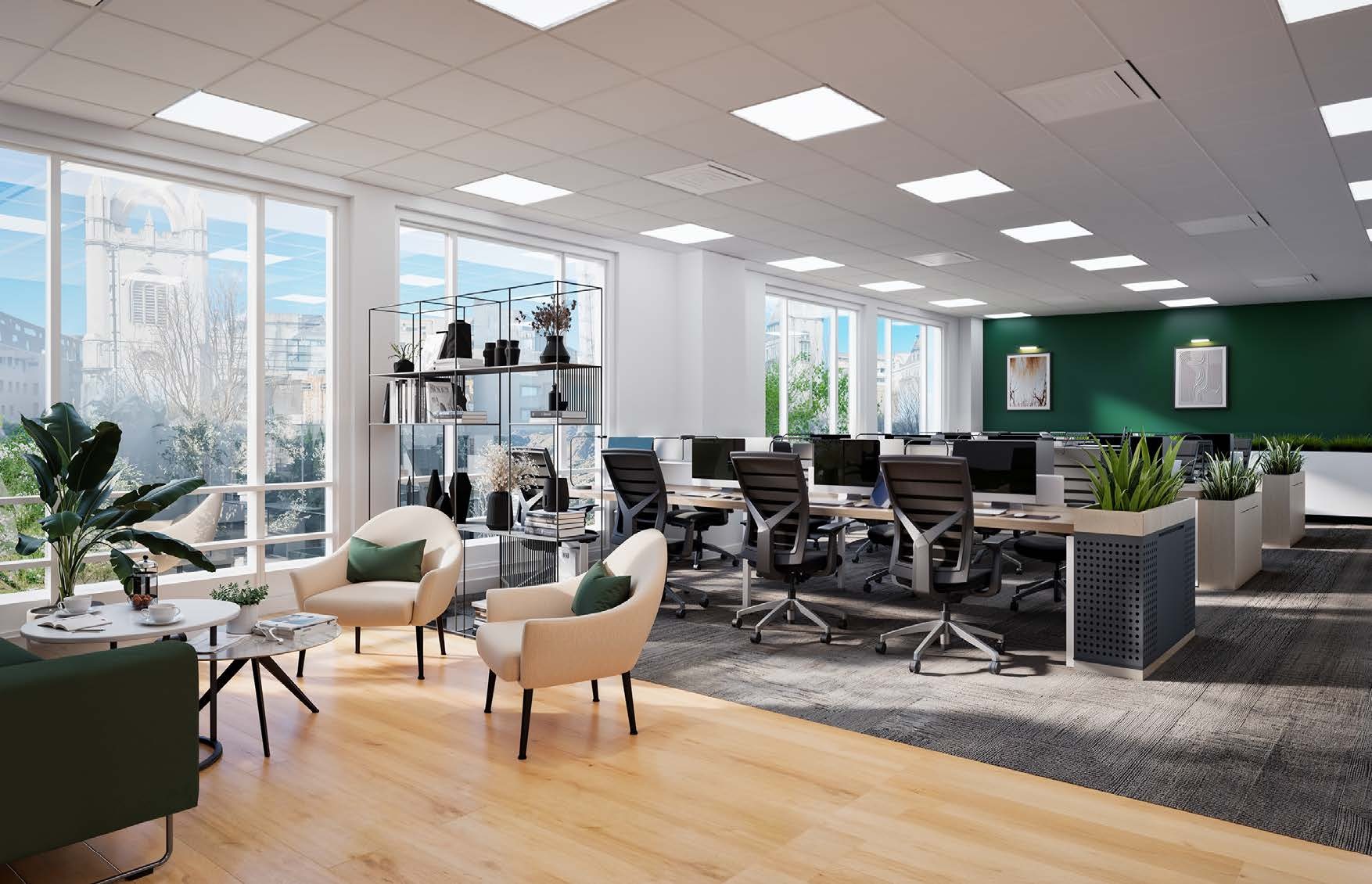 Modern open-plan office with beige chairs, dark desks, green accent wall, large windows, plants, and white ceiling lights.